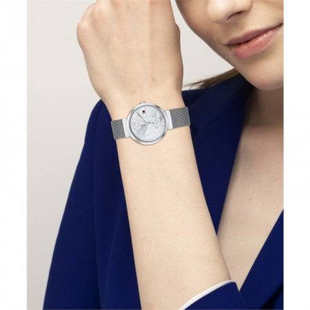 Tommy Hilfiger THGIFTSETLIBBY Libby dameshorloge 32mm met zilverkleurige wijzerplaat en mesh band, gedragen door een vrouw in een blauwe outfit.